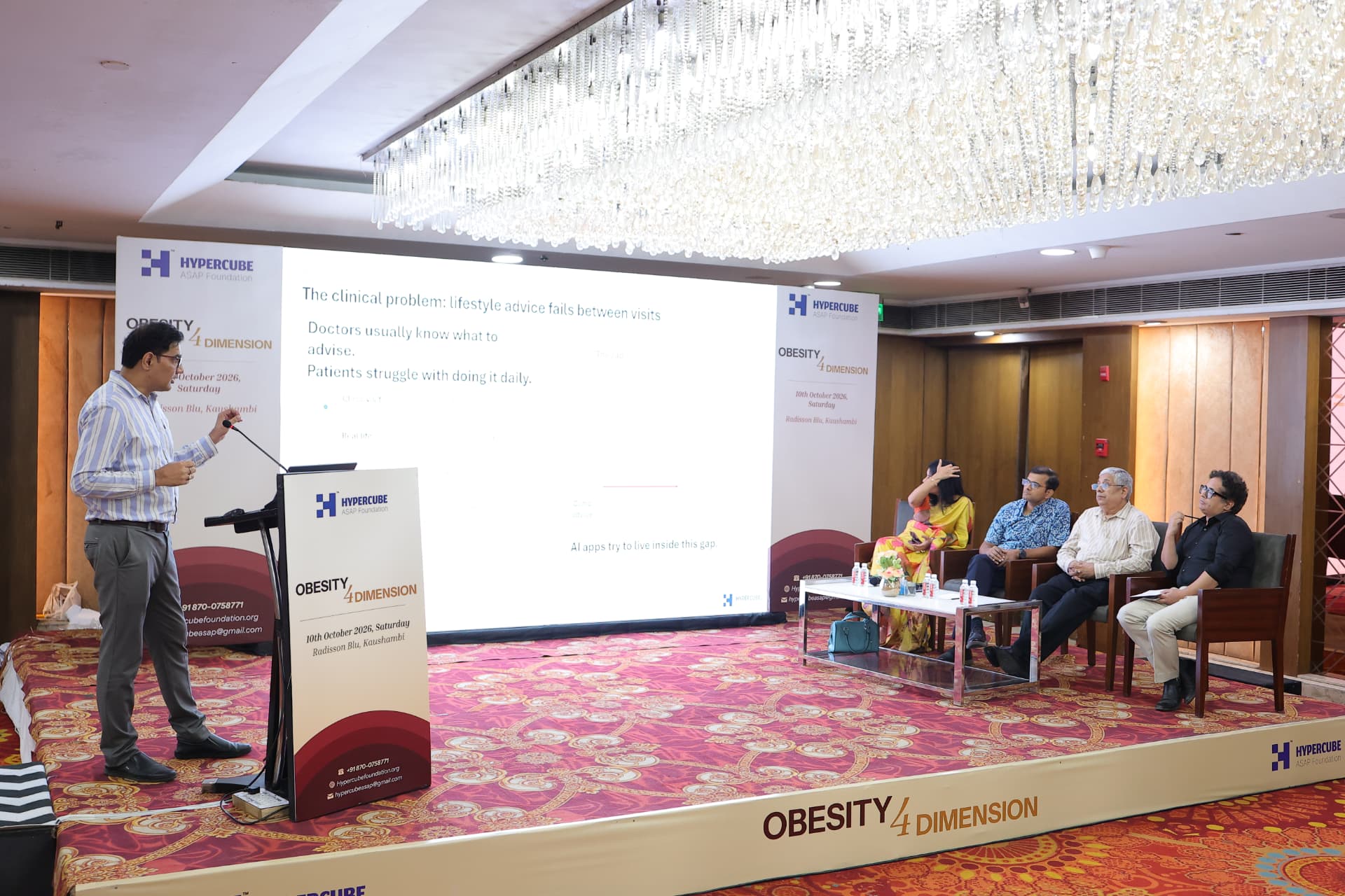 Speaker presenting on stage with the panel at the Obesity 4 Dimension CME